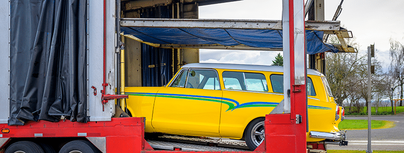 vintage yellow car being loaded on trailer