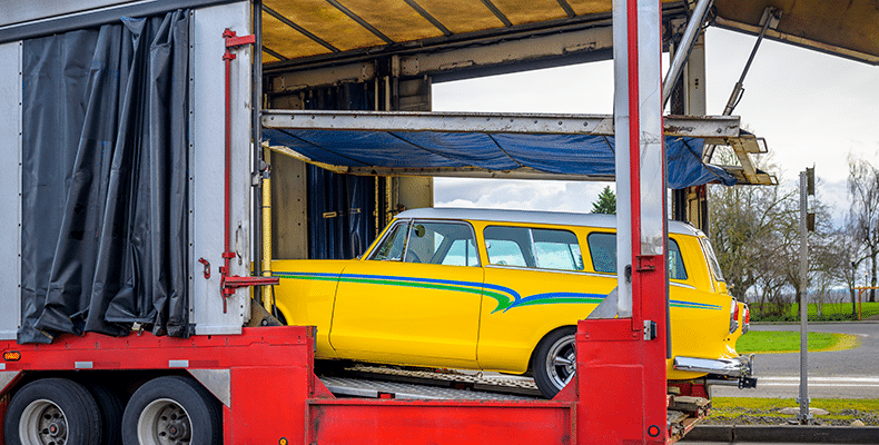 Vintage vehicle being loaded for enclosed car transport